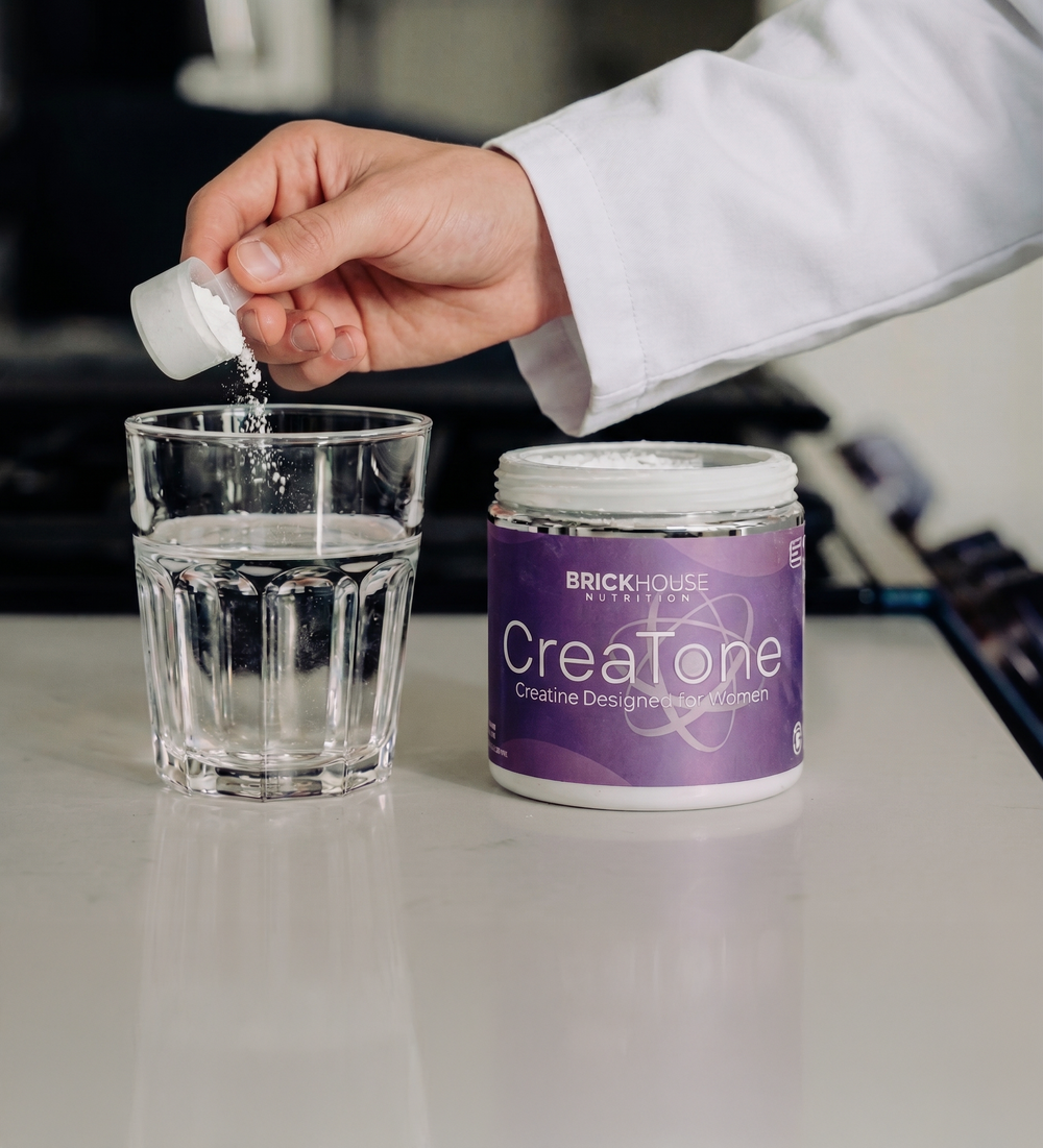 Creatine supplement being added to a glass of water